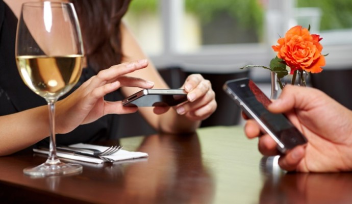 Hände mit Handys im Restaurant